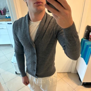 Grå  cardigan från Imperial, slim fit - Säljer en stilren grå cardigan från Imperial med smal passform. Koftan har ribbade detaljer vid axlar och krage, knäppning framtill och är långärmad. Perfekt för lager-på-lager och passar till många olika outfits. Bra skick men lätt nopprig. Sitter som xs 