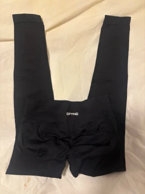 Svarta leggings från DFYNE - Säljer ett par svarta leggings från DFYNE med hög midja och tight passform. De är aldrig använda då dom var för små o jag glömde skicka tillbaka i tid