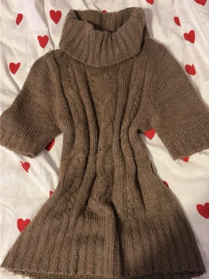 Brun stickad polotröja från Madonna - Säljer en brun stickad polotröja från Madonna i storlek m/s med grov kabelstickning och bred polokrage. Tröjan har korta ärmar och är ribbad i både muddar och nederkant.                                                                Tröjan har utsträckt tyg på vissa platser pga användning (se bild 4/5) annars finns inga andra defekter💕