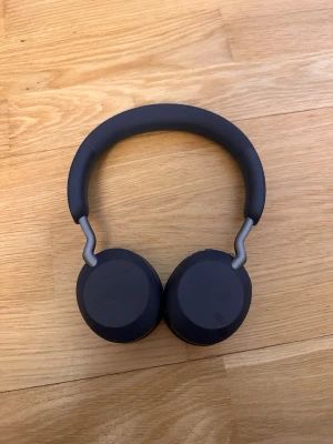 Jabra Elite 45h - Jabra Elite 45h trådlösa over-ear hörlurar i blått. Lätta och bekväma med lång batteritid och tydliga reglage. Viss kosmetisk slitage syns på kåporna, men i övrigt gott skick. Perfekta för musik och samtal med bra ljudkvalitet. Inga tillbehör följer med!.