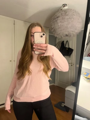 Ljusrosa stickad tröja - Supermjuk ljusrosa stickad tröja med rund halsringning och långa ärmar. Enkel och stilren modell som är perfekt att slänga på sig till jeans eller kjol. Tröjan har ribbade muddar vid ärmslut och nederkant för en snygg passform. Skulle gissa att de är en storlek M eller L.