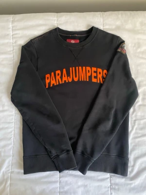 Parajumper tröja  - Ett svart parajumper tröja med texten Parajumper i framsidan med storleket L men kan passa som M, om du har några frågor så smsa mig