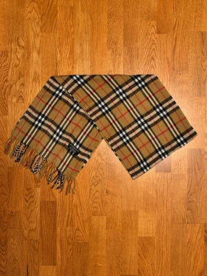 Beige Burberry halsduk - Säljer en beige halsduk från Burberry. Halsduken är gjord i lamull och är i gott skick. Var inte rädd för frågor. Pris diskuteras inte!
