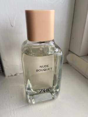 ZARA Nude Bouquet parfym - Säljer en nästintill oanvänd stilren parfym från ZARA med enkel design och modern känsla. Perfekt för dig som vill ha en fräsch och blommig doft✨Flaskan är 100ml