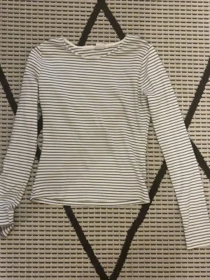 Randig långärmad topp från Vailent - Säljer en vit långärmad topp från Vailent Essentials i storlek S. Toppen har tunna svarta horisontella ränder och en klassisk rund halsringning. Materialet är mjukt och stretchigt, super skön.