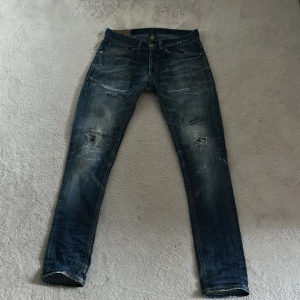 Dondup - Säljer ett par blå Dondup jeans med skinny passform och coola slitningar på benen. Jeansen har klassisk femficksdesign, dragkedja och knapp i midjan. Materialet är jeans med snygg tvätt och detaljerade slitningar som ger en edgy vibe. Pris kan diskuteras!