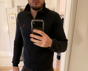 Marinblå half zip från Polo Ralph Lauren - Säljer en marinblå långärmad tröja från Polo Ralph Lauren med klassisk röd logga på bröstet. Tröjan har en snygg half zip-dragkedja och står krage. Tillverkad i mjuk bomull för skön passform. Jättebraskick 9/10. Kan diskuter om priset! 