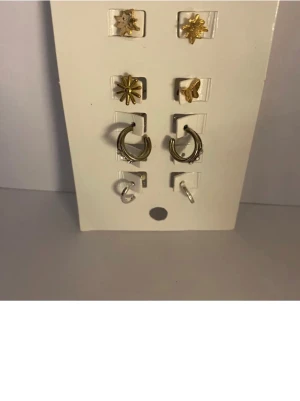 Ingen väst på bilderna - Ett  set med örhängen i olika former och färger silver och guld .aldrig använda 