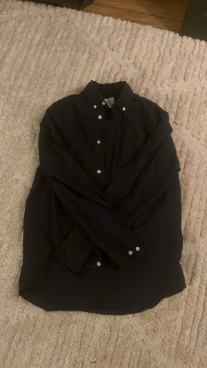 MÖRKBLÅ SKJORTA - Mörkblå HM Skjorta storlek S. Finns små synliga defekter, på storlekslappen och på vänster arm. Finns bilder. Använts fåtal gånger.