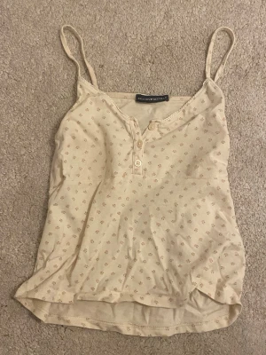 Blommig linnetopp  - Jätte sött linne från brandy melville i ljusbeige med små blommor i rosa och grönt. Använd men i jätte fint skick 