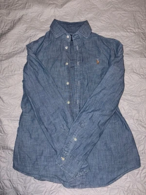 Blå skjorta från Polo Ralph Lauren - Säljer en stilren blå skjorta från Polo Ralph Lauren i slim fit-modell.