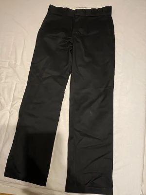 Dickies byxor  - Säljer ett par svarta byxor från Dickies 874 original fit ,med klassisk rak passform. Byxorna har midwaist och är gjorda i ett slitstarkt bomullsmaterial. De har diskreta fickor och en enkel design som funkar till många olika stilar. Dickies-loggan syns på bakfickan.