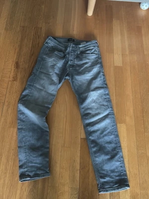 Grå tapered jeans Tapered/Mike 29/30 - Snygga grå jeans från Tapered/Mike i storlek 29/30. Modellen är tapered med smalare ben och klassisk femficksdesign. Jeansen har en cool tvättad look och är tillverkade i mjukt denim-material som sitter skönt hela dagen.