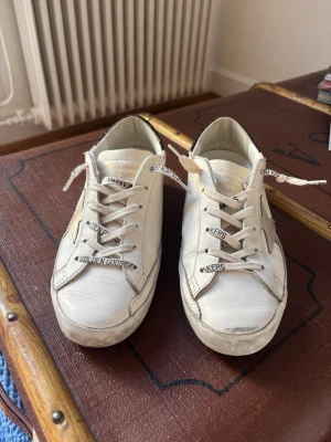 Golden Goose Superstar - *Endast använda ett par gånger! Säljer nu dessa jättefina sneakers från Golden Goose, i mycket bra skick. Modellen heter Super-star sneaker white/platinum/burgundy och skorna är i storlek 38. Tyvärr insåg jag att de inte riktigt är rätt storlek för mig. Jag har kvar skokartong, dustbag och garantikort☺️Nypris ca 6200 kr!