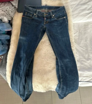 Lågmidjade jeans - As lågmidjade jeans från DSQUARED2. Midjemåttet är 39cm. Grenen är 16,5cm hög(se sista bilden). Innerbenslängen är 82,5cm