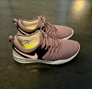 Nike Free lila träningssko med snörning - Nike Free sneakers i en snygg dov lila ton. Skorna har snörning, svart och ljusrosa Nike-logga på sidan. Stl 36,5.