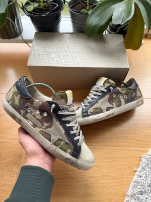 Sällsynta Golden Goose skor - Hej, säljer nu ett par sinnessjukt snygga Golden Goose camo skor. | Dom är omöjliga att köpa nya och en väldigt sällsynt sko. | Väldigt bra skick som visas på bilderna, litet märke på sidan men inget som märks av. | Endast skorna igår! | Hör av er vid frågor!🌟