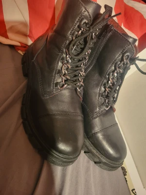 Winter boots  - Rieker boots almost new. Size 38, warm lining, side zipper, unique chain lace up. There is some very minor scuffing which is notable upon close inspection. New price 1095sek