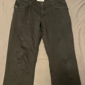 Svarta jeans från Tiger Of Sweden - Snygga svarta jeans från Tiger of sweden med klassisk femficksdesign och bootcut passform. Jeansen har normal midja och raka ben som blir lite vidare nedtill. Tillverkade i mjukt bomullstyg med en stilren look, perfekta för dig som gillar en avslappnad men ändå trendig stil.