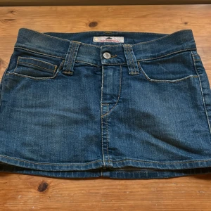 Lågmidjad kort jeanskjol  - Super fin lågmidjad jeanskjol som är i kort modell vintage i s men skulle säga mer xs 