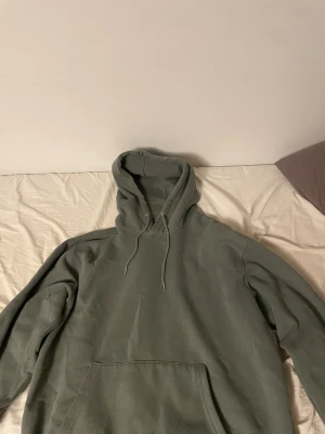 Grön hoodie från Jack & Jones - Säljer en enkel grön hoodie från Jack & Jones med huva och snörning. Tröjan har en stor magficka framtill och är tillverkad i mjuk bomull. Perfekt för chill dagar och har en klassisk loose passform med långa ärmar.