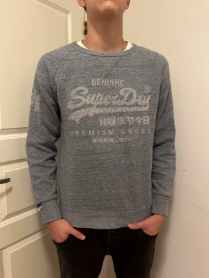 Superdry Tröja - Säljer denna feta sweatshirten från Superdry. Riktigt inne just nu med ”vintage” tryck. Storlek M, modellen är 186cm, 72kg.