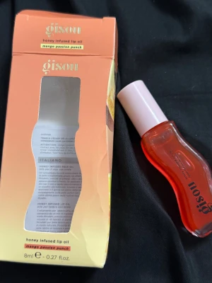 Gisou Honey Infused Lip Oil Mango - Gisou Honey Infused Lip Oil i färgen Mango Passion Punch, 8 ml. Kommer i en snygg, kurvig genomskinlig orange flaska med ljusrosa lock. Oljan är berikad med honung och ger glansiga, mjuka läppar med en fruktig doft och lätt tint. Perfekt för dig som vill ha juicy lips med extra shine.