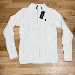Ralph Lauren Zip Knit - White Ralph Lauren Polo Zip Knit Stilren, mjuk och väldigt bekväm zip-knit från Ralph Lauren. Perfekt för både vardag och finare tillfällen. En tidlös och elegant tröja som passar extra bra nu under vintern och inför julens alla tillfällen.