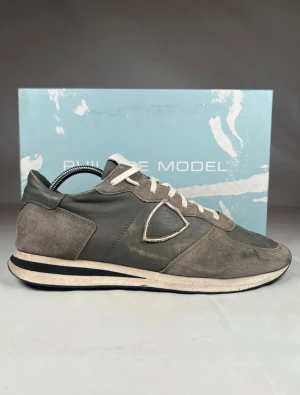 Grå Philippe Model sneakers - Säljer dessa gråa Philippe models i storlek 43 men passar 44. Dem är i bra skick och har tagits hand om men är använda.  Skolådam följer självklart med och skoträd ifall begärt. Priset är inte satt i sten. Skriv ifall ni behöver fler bilder eller har funderingar. 