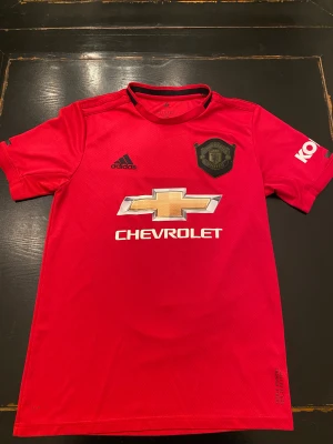 Manchester United kit 2019/2020 - Röd Manchester united kit från adidas. 2019/ 2020 hemma kit. Jag är 190 cm lång och den är lite för liten men den är stor i storlek.