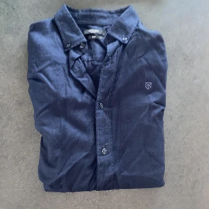 Mörkblå skjorta från Jack & Jones S - Mörkblå skjorta från Jack & Jones Premium i slim fit. Klassisk krage, knäppning framtill och diskret broderad logga på bröstet. Skjortan är tillverkad i mjuk bomull och passar perfekt till en stilren look. Säljer pga att jag växt ut den. Lätt att kombinera med många färger