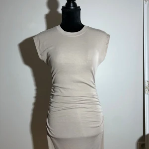 Beige långklänning från Amisu - Snygg klänning med resår i midjan. Längd ca 130cm. Pris: 30kr