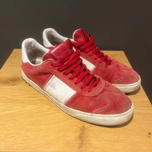 Valentino flycrews - Snygga röda Valentino flycrews med mockaöverdel och kontrasterande vita paneler. Skorna har rund tå, platt sula och röda snören. Satt på egna nitar då många har ramlat av