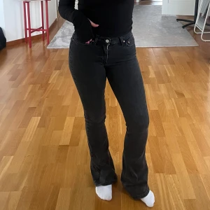 Svarta bootcut jeans från gina tricot - Snygga svarta jeans med bootcut passform och klassisk femficksdesign. Jeansen har en mörk tvätt och sitter skönt i midjan. Perfekta för dig som gillar en tidlös och cool stil.