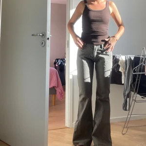 Grå bootcut jeans  - Säljer ett par grå jeans med bootcut passform. Byxorna har hög midja.