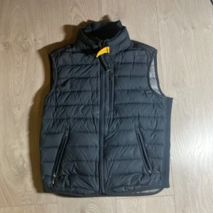 Svart dunväst från Parajumpers - Säljer en mörkgrå väst från parajumpers. Har använt den ett tag nu men inget stort, bara ett litet hål vid vänstra fickan. Den passar 146-152. Köpte den ny för 1500. Säg bara till om du undrar något!
