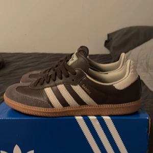 Adidas Samba OG bruna sneakers - Tja, säljer ett par Adidas samba skor i stl 39 1/3. Skorna är i princip nytt skick har använt de två/tre gånger. Hör av dig vid frågor!