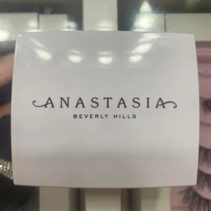 Anastasia Beverly Hills highlighter - Supersnygg highlighter från Anastasia Beverly Hills i en lyxig, roséguldig dosa med spegel. Pudret har en skimrande, ljus champagnefärg och ett coolt mönster i ytan. Perfekt för att ge glow till kindbenen eller ögonvrån.