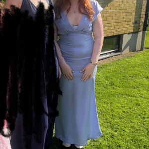 Ljusblå långklänning/balkläning - Säljer en elegant ljusblå långklänning med v-ringning och spetsdetalj framtill. Spetsen har jag själv sytt för att minska öppenheten men det kan nog tas bort om man vill. Jag är ca 162 och har oftast m, ibland s på överdelar och denna satt perfa. Superfin färg som varken var för stark eller tråkig. Ryggen är lite öppen och har en fin korsnings detalj. Skriv om ni har mer frågor(Finns en liten röd prick, se sista bilden, väldigt liten och kanske går bort) 🫶🏼( SKRIV innan köp💋)