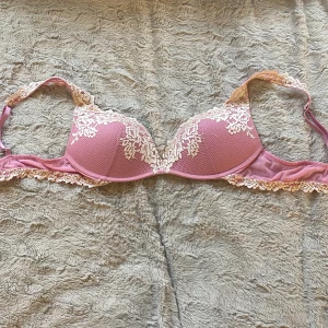 Rosa spets-bh med blommig detalj - Söt rosa bh med vadderade kupor och vacker vit spets i blommigt. Strlk 75 C. 