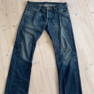 jeans från Lee - Snygga blå jeans från Lee i regular fit. Jeansen har fem fickor, slitna detaljer och Lee-läderpatch bak i midjan. Tillverkade i robust denim med snygg tvätt och kontrastsömmar. Perfekta för dig som gillar en avslappnad och tidlös stil.