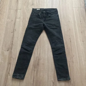 Svarta Levis Slinny taper 511 W30 L32 - Säljer ett par svarta Levis 511 jeans i storlek W30 L32. Modellen är slim fit med klassisk femficksdesign och Levis-logga på bakfickan. Perfekta svarta jeans med rak passform och snygg look.