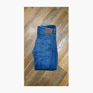Blå Replay jeans straight fit - Säljer ett par klassiska blå jeans från Replay med raka ben och snygg tvätt. Jeansen har fem fickor, läderpatch med Replay-logga bak och diskreta slitningar för en cool look. Perfekta för dig som gillar en tidlös stil. Obs skulle nog säga att storleken är mer W32-L33