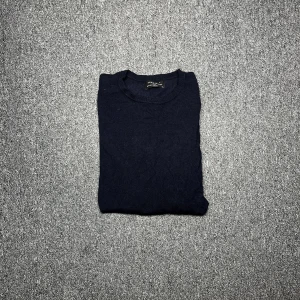 Mörkblå stickad tröja från Zara Man S - En stilren mörkblå stickad tröja från Zara Man. Klassisk rund halsringning och långa ärmar. Perfekt för lager-på-lager och funkar lika bra till jeans som till chinos. Enkel och tidlös design som passar till många olika outfits.