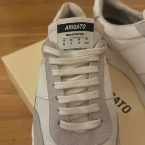  Arigato - Axel Arigato sneakers – 1200 kr  Säljer ett par snygga och stilrena sneakers från Axel Arigato, modell tillverkad i Portugal. Storlek EU 42 (UK 8 / US 9). Skorna är i mycket fint skick, endast provade inomhus (se bilder). Kommer med originalkartong.  Nypris ligger runt 2000–2500 kr, så detta är ett bra kap! Finns att hämta i Göteborg eller kan skickas mot fraktkostnad.    ENDAST SERIÖS KÖPARE!!