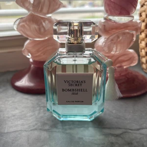 Victoria's Secret Bombshell Isle - Bombshell Isle Eau de Parfum från Victoria's Secret. Snygg flaska med fräsch vibe, perfekt för dig som vill sticka ut och ge din stil en extra boost. Limited edition, se bild hur mycket som använts. 50ml