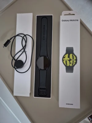 Samsung Galaxy Watch6 - Använd ett fåtal gånger och i bra skick. Det finns några mindre repor på kanten vid knapparna (se bild 2), men inget som påverkar funktion eller användning.  Originalförpackning och laddarsladd (USB-C) medföljer, dock utan strömadapter. Klockan är återställd och redo för ny ägare.