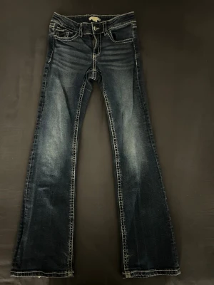 Mörkblå bootcut jeans från Gina Tricot - Mörkblå jeans från Gina Tricot i storlek 164 i bootcut-modell och kontrastsömmar. Klassisk femficksmodell med knapp och dragkedja fram. Jeansen har lite slitningar vid bensluten (se bild 3) men annars ganska bra skick. Säljer eftersom de inte kommer till användning💞