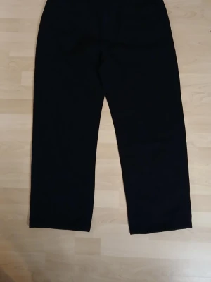 Svarta byxor från Temu i bomullsblandning XL - Säljer ett par svarta byxor i storlek XL med rak passform. Tillverkade i en mjuk bomullsblandning med polyester och viskos för extra komfort. Byxorna har enkel design utan synliga detaljer och passar perfekt till en avslappnad stil. Från Temu!