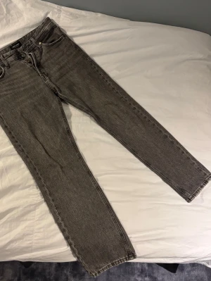 Grå jeans från Jack & Jones  - Säljer ett par jeans som inte längre kommer till användning. Det är ganska använda men inga defekter eller liknande. Storleken är W28 och 30 i längden. 